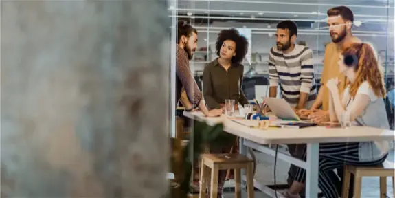 stand up meeting around a tall desk
