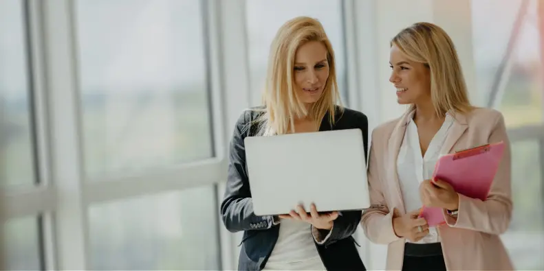 Two business women discussing work over laptop Two business women discussing work over laptop