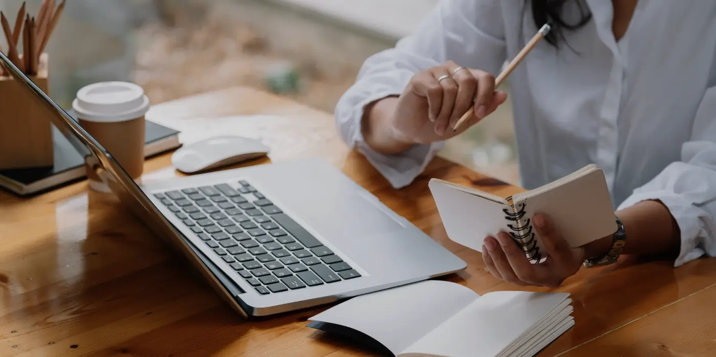 Person working at desk with laptop and pencil