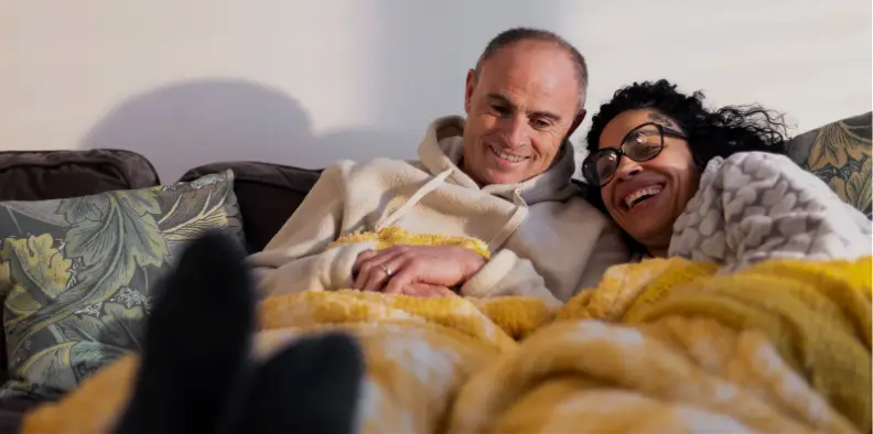 Couple cwtching on the settee Couple cwtching on the settee