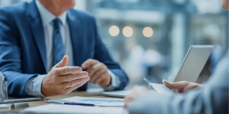 Man in a suit discussing something over the desk