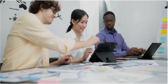 People working around desk with laptops